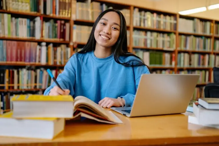 Student learning web development classes online with laptop and books for website designing and digital skills training